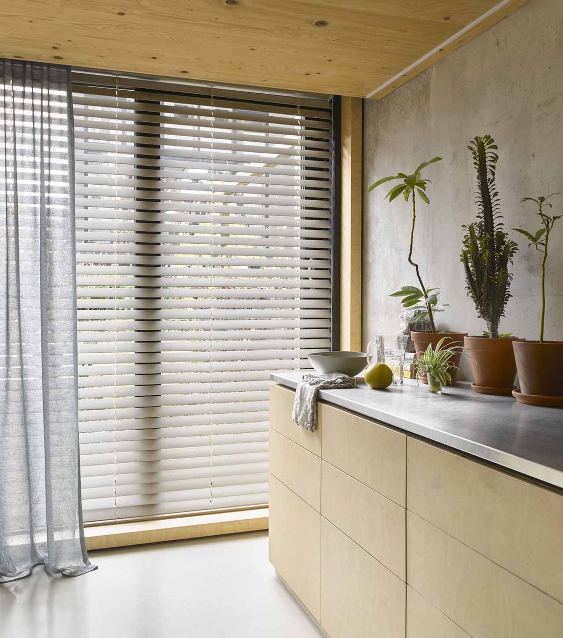 Houten jaloezie voor het raam van een keuken