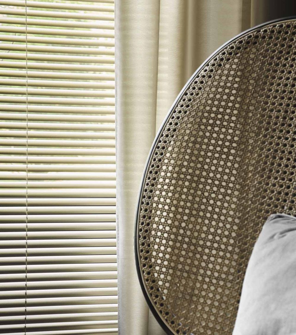 Aluminium jaloezie voor een raam in een lichte kamer